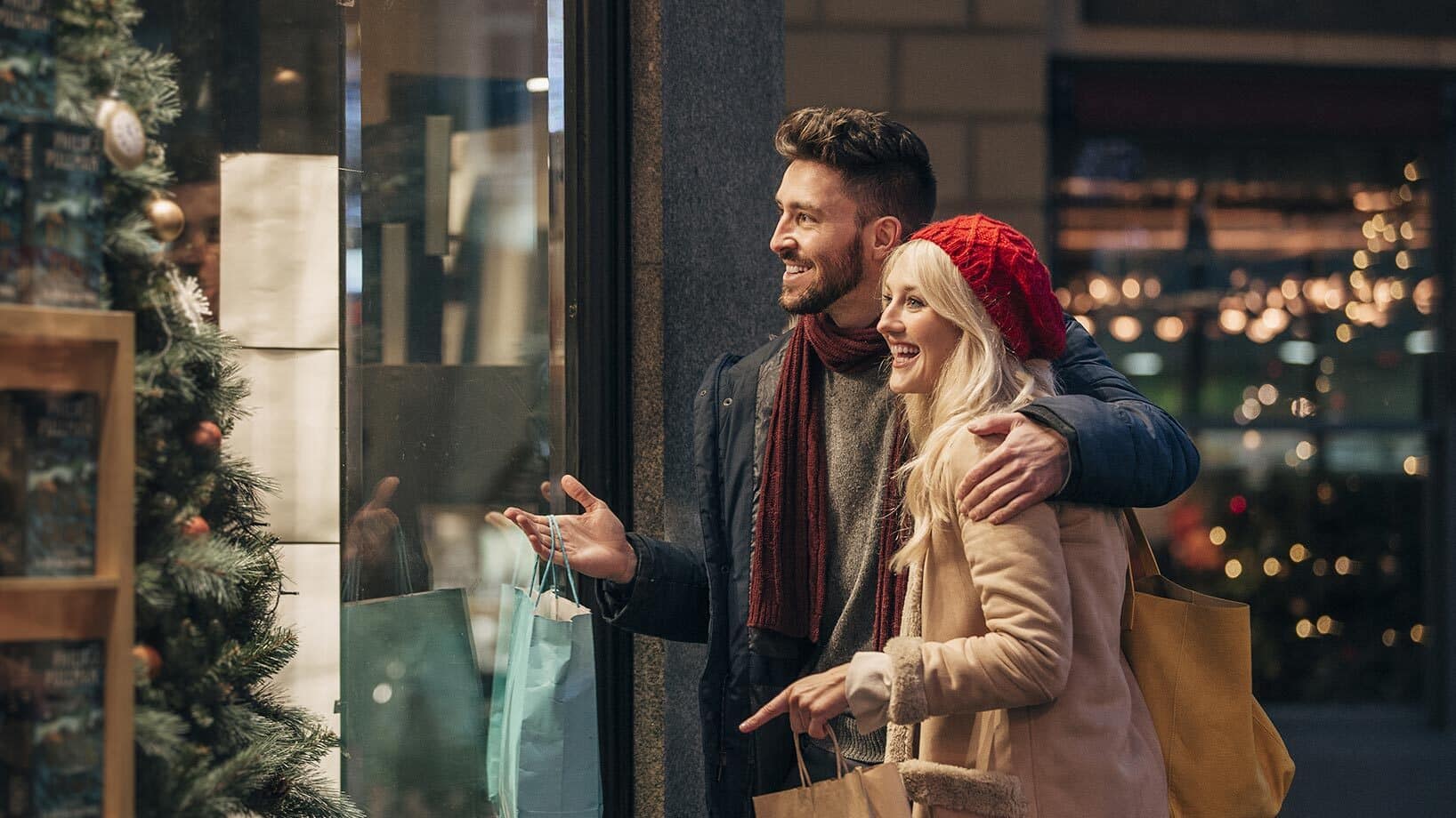 Das Bild zeigt ein Pärchen bei ihren Weihnachtseinkäufen. Visualisiert wird hier die peak season im E-Commerce.