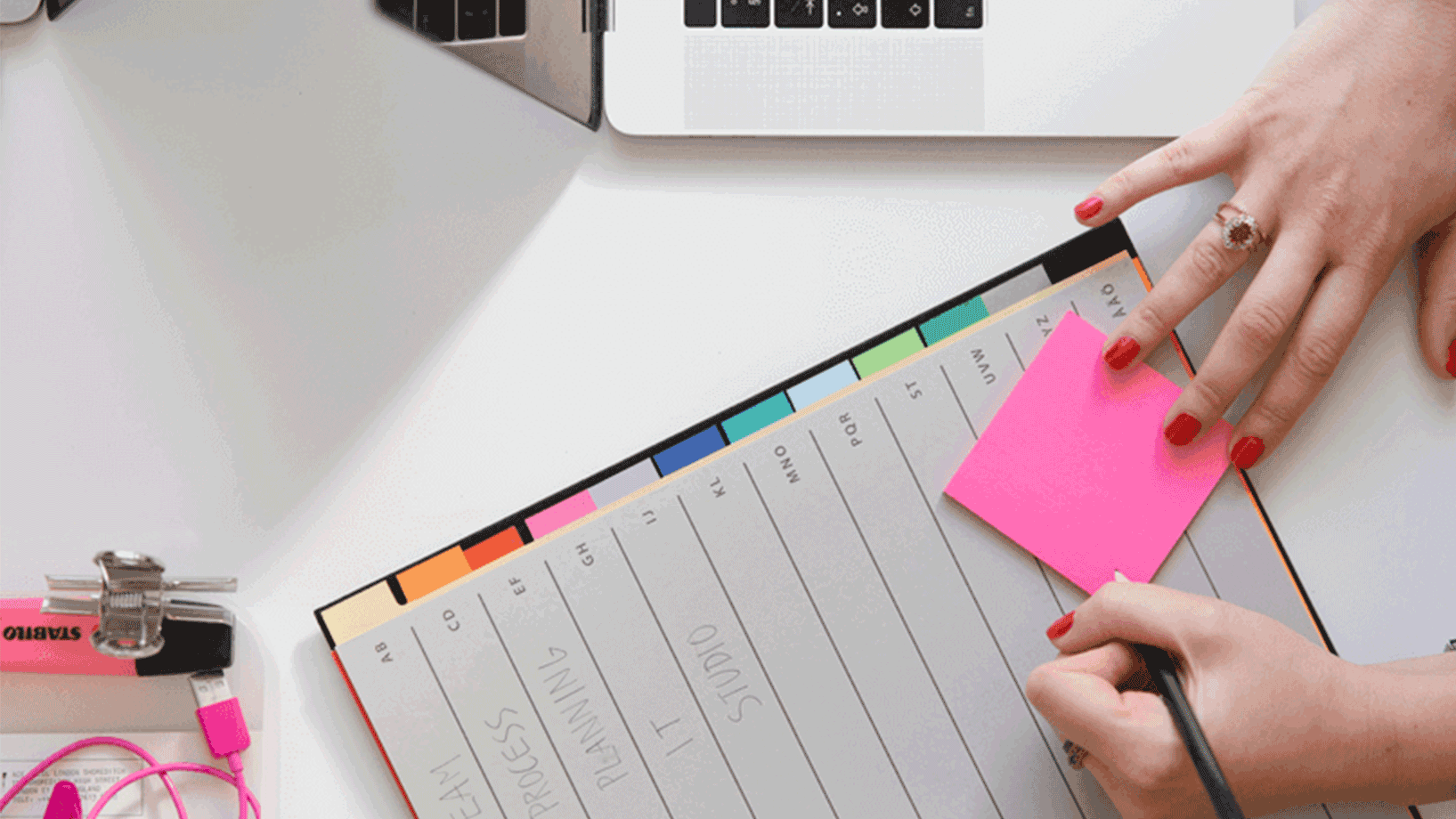 Das Bild zeigt eine Frau, die einen Post-it als Merkzettel verwendet.