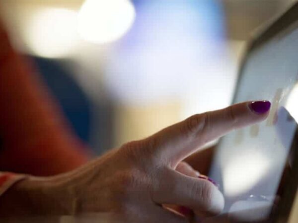 Dieses Bild zeigt die Hand einer Frau, welche auf ein Tablet tippt.
