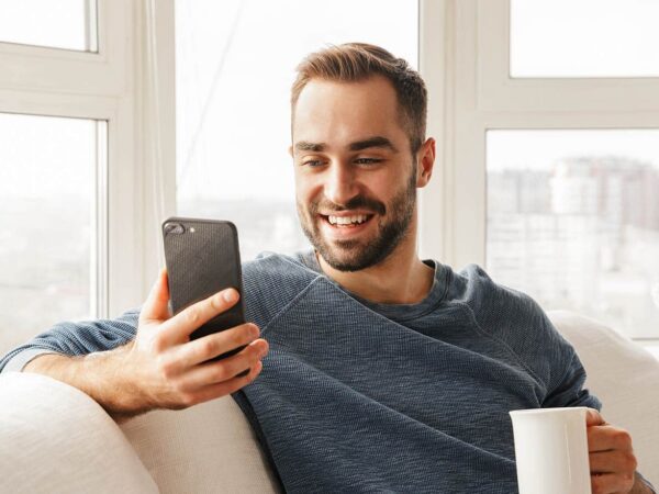 Das Bild zeigt einen Mann der im Café seine Mails checkt.
