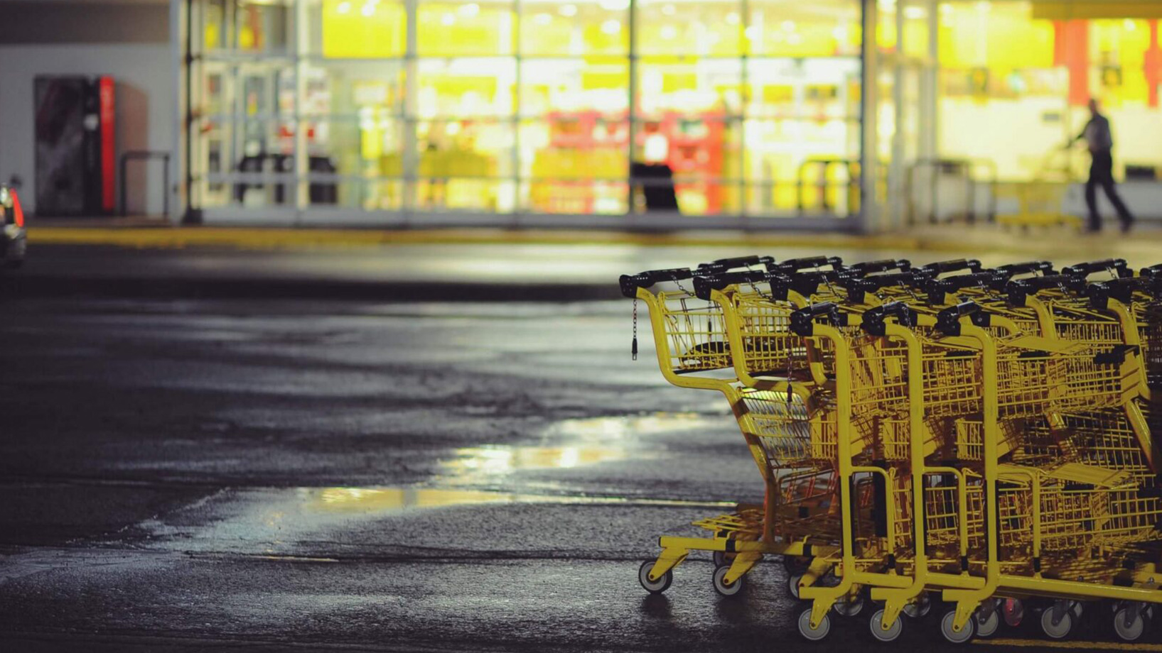 Das Bild zeigt eine Einkaufswagen Schlange vor einem Supermarkt.