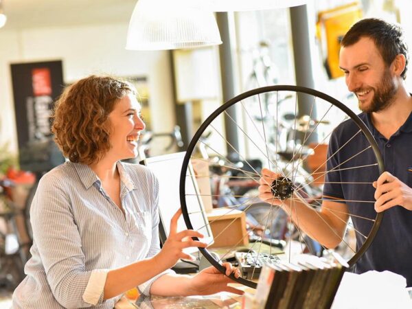 Das Bild zeigt eine Frau, die beim Kauf eines Fahrrad-Rades beraten wird. Hierbei wird das one-to-one-marketing verkörpert.