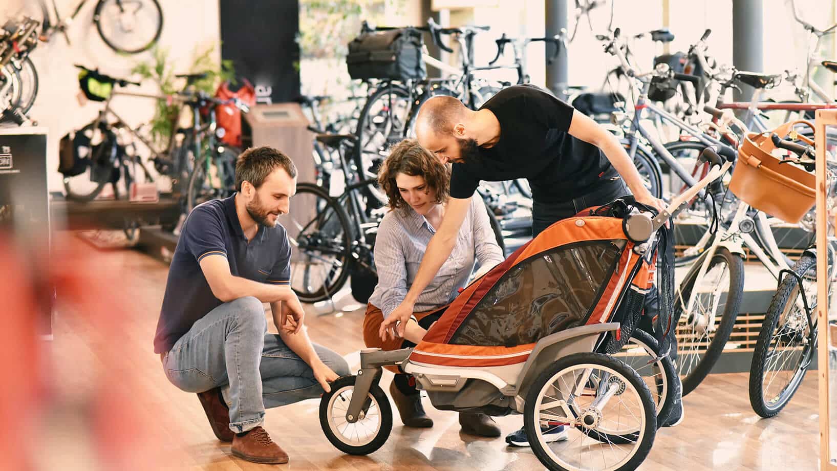 Das Bild zeigt die Beratung eines Paares beim Kauf eines Fahrrad Kinderanhängers.