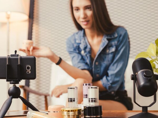 Junge Frau präsentiert Beautyprodukte in Form von Live Video Shopping.