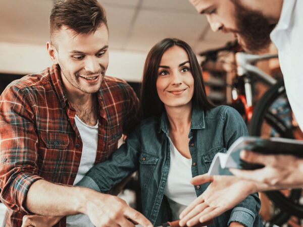 Zwei Männer und eine Frau in einem Fahrradgeschäft