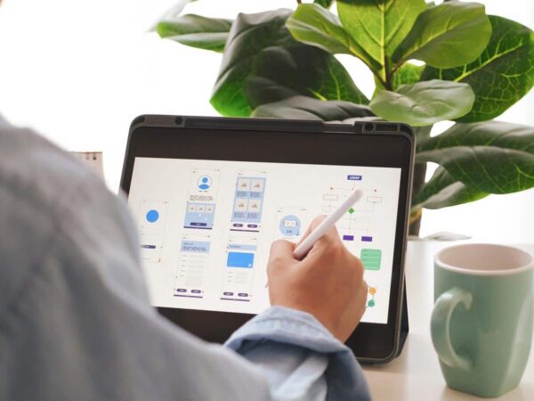 Das Bild zeigt eine Person, die Entwürfe für die UX im E-Commerce auf einem Tablet bearbeitet.