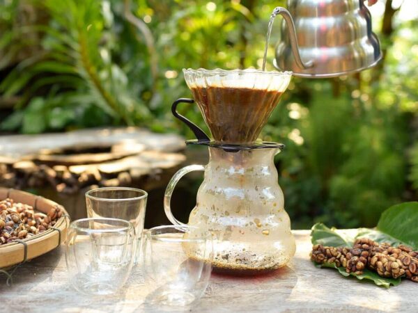 Das Bild zeigt einen Kaffeefilter, in den Wasser gegossen wird.