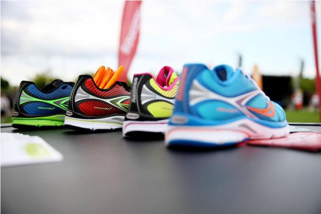 4 verschiedene, bunte Laufschuhe stehen aufgereiht nebeneinander.