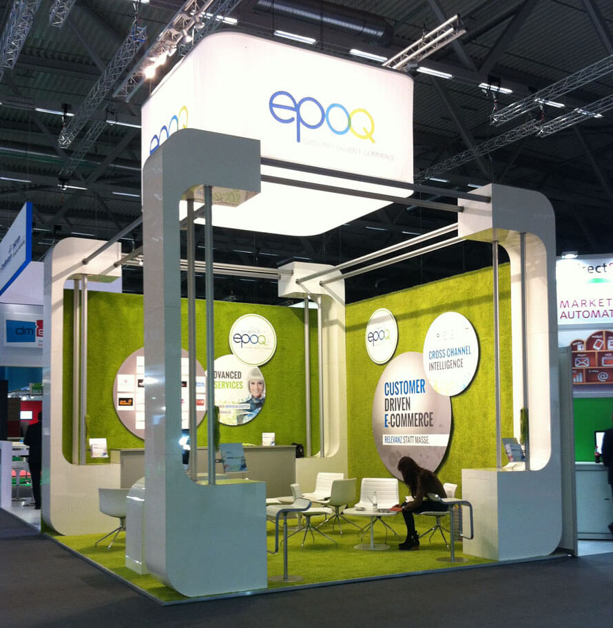 Auf dem Bild ist der epoq-Messestand auf der dmexco 2013 zu sehen. Die Wände sind hellgrün und über ihm leuchtet das epoq-Logo. Eine Person sitzt darin.
