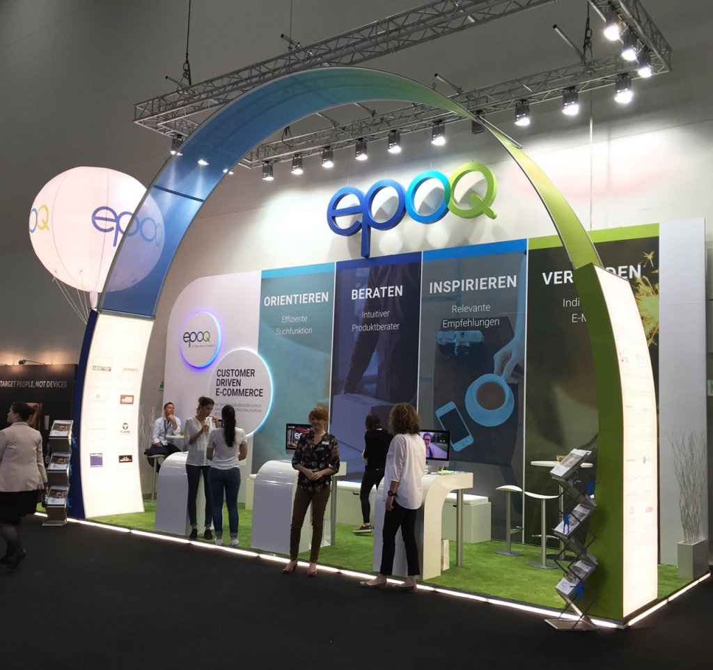 Der epoq-Messestand auf der dmexco 2016 ist zu sehen. Mehrer Leute stehen darin und unterhalten sich.