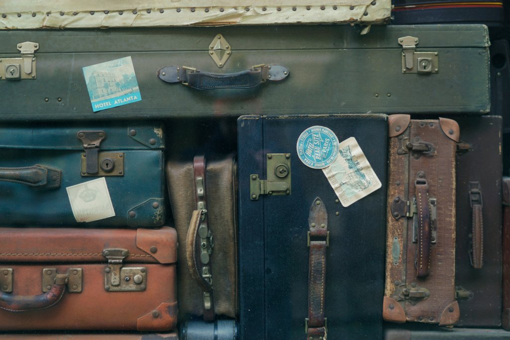 Viele aufeinandergestapelte Vintagekoffer in unterschiedlichen Größen, Formen und Farben. Sie stehen für die große Auswahl in Onlineshops, bei der ein Produktberater dem Kunden in der Entscheidung unterstützt.