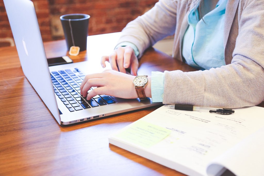 Eine Frau am McBook, die im B2B E-Commerce tätig ist.