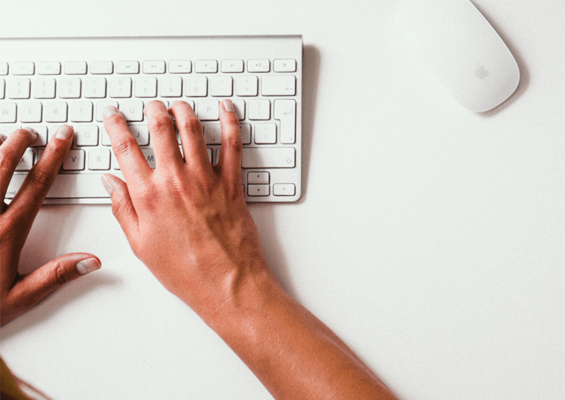 Person tippt auf Tastatur und löst durch Rechtschreibfehler fehlertolerante Suche aus