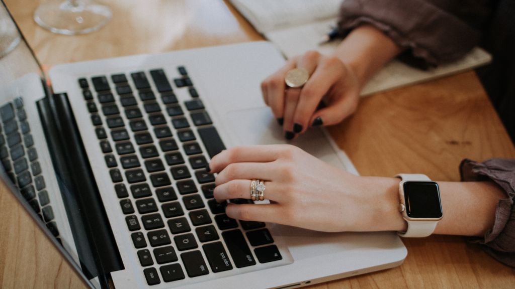 Frau tippt auf der Tastatur eines Notebooks