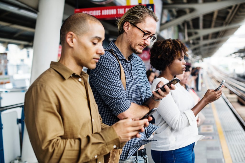 Das Bild zeigt 3 Personen die ihr Smartphone nutzen und dadurch zu Big Data im E-Commerce beitragen.