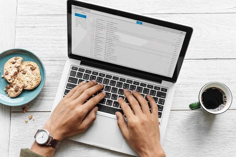 Das Bild zeigt einen Laptop, an dem eine Person arbeitet. Auf dem Laptop ist ein E-Mail-Programm geöffnet. Der Artikel enthält hilfreiche Newsletter-Tipps.